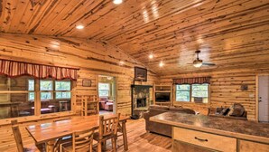 Ein Holzblockhaus-Innenraum mit Essbereich, Küche und Wohnzimmer.