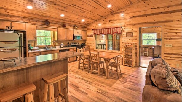 Ein gemütliches Holzhaus-Interieur mit einer Küche, Essbereich und einer Sitzecke.