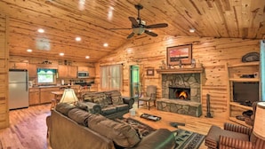 A log cabin interior with a living room, fireplace, television, and kitchen area. - Mountain Laurel 2/2! Pool table! Firepit! Close to Helen. (Clarkesville)