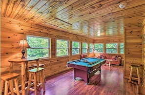 A wooden cabin interior with a pool table, bar stools, and a sofa. - Mountain Laurel 2/2! Pool table! Firepit! Close to Helen. (Clarkesville)