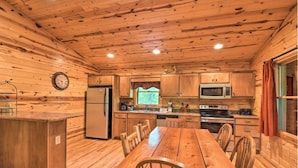 A wooden cabin interior with a kitchen, dining table, and chairs. - Valley View 2/2! Pool Table! Near Helen! (Clarkesville)
