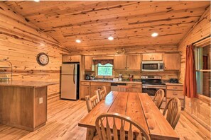 A wooden cabin interior with a kitchen, dining table, and chairs. - Valley View 2/2! Pool Table! Near Helen! (Clarkesville)