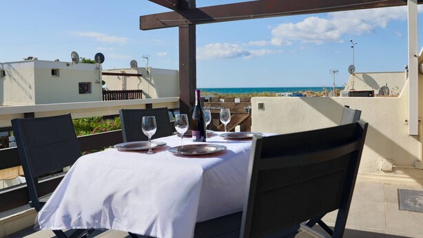 A table set for dining with a view of the sea, under a wooden pergola. - PINK LADY - Villa Port Nature 12 - Luxury - 4 people (AGDE)