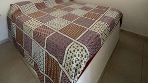 Ein Schlafzimmer mit einem Bett, einem Wandbild und einer Tür.