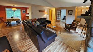 A living room with a sofa, coffee table, and a dining table with chairs.