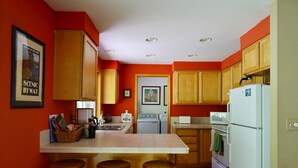 A kitchen with wooden cabinets, a white refrigerator, a stove, and a sink.