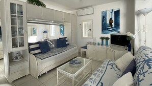 A living room with a sofa, a coffee table, a TV, and a cabinet. - Villa Port Nature 134 - 2 people (AGDE)