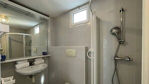 A bathroom with a toilet, sink, mirror, shower, and a small window. - Villa Port Nature 134 - 2 people (AGDE)