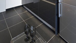 Una cocina moderna con un refrigerador de acero inoxidable, un microondas integrado y una cafetera.