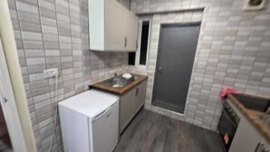A compact kitchen with a refrigerator, sink, and cabinets. - Room 3 in sheffield (Sheffield)
