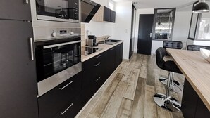 A modern kitchen with a built-in oven, microwave, and stainless steel appliances. - VOLUPTIA  - Villa Port Nature 54 - Luxury - 4 people (AGDE)