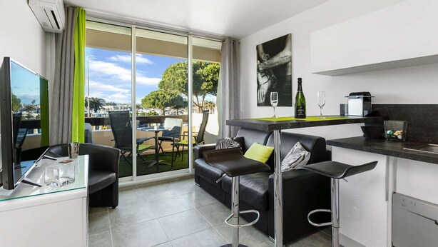 A modern apartment with a living area, a kitchen, and a balcony with a view. - CARESSE - Studio Port Nature PN620 - Luxe - 2 people (AGDE)
