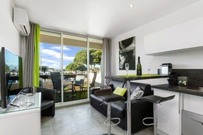 Un appartement moderne comprenant un espace de vie, une cuisine et un balcon avec vue.