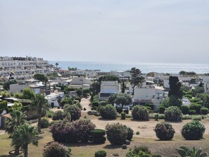 Ein Küstenwohngebiet mit modernen Gebäuden, freiem Blick auf das Meer und gepflegten Gärten.