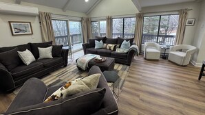 A spacious living room with a high ceiling, large windows, and a balcony. - Epic Renovated Slopeside Unit feet from Camelback Mountain- Laurel Glade Trail. (Tannersville)