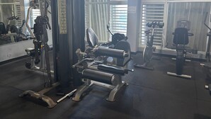 A gym with exercise equipment, large windows, and a mirror. - Beachfront apartment w pools, tennis, gym parking in TOP PR TOURISM CONDADO SJU (Luquillo)