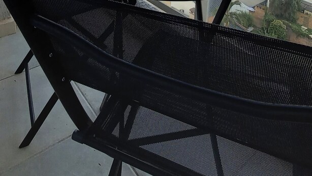 Un balcon avec une table et des chaises, d’où l’on peut admirer la vue sur la ville.
