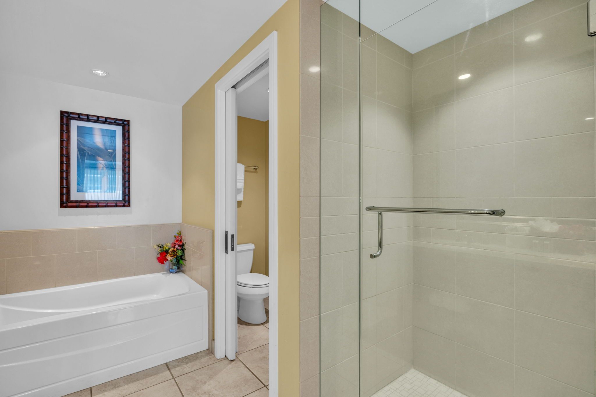 Une salle de bain équipée d’une baignoire, de toilettes et d’une douche à parois en verre.