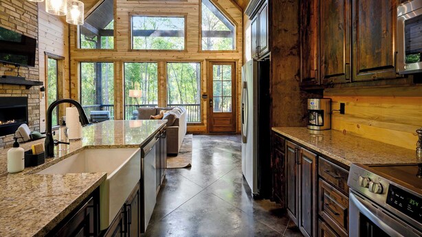 A kitchen with a large island, granite countertops, and stainless steel appliances. - Modern Glass Cabin w/ Hot Tub & Outdoor Lounge (Broken Bow)