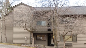 A two-story building with a flat roof, a front entrance, and a parking lot with marked spaces. - Marina Cay Condo | Sleeps 4 | Steps from Flathead Lake, Bigfork Village & Glacier Country (Bigfork)