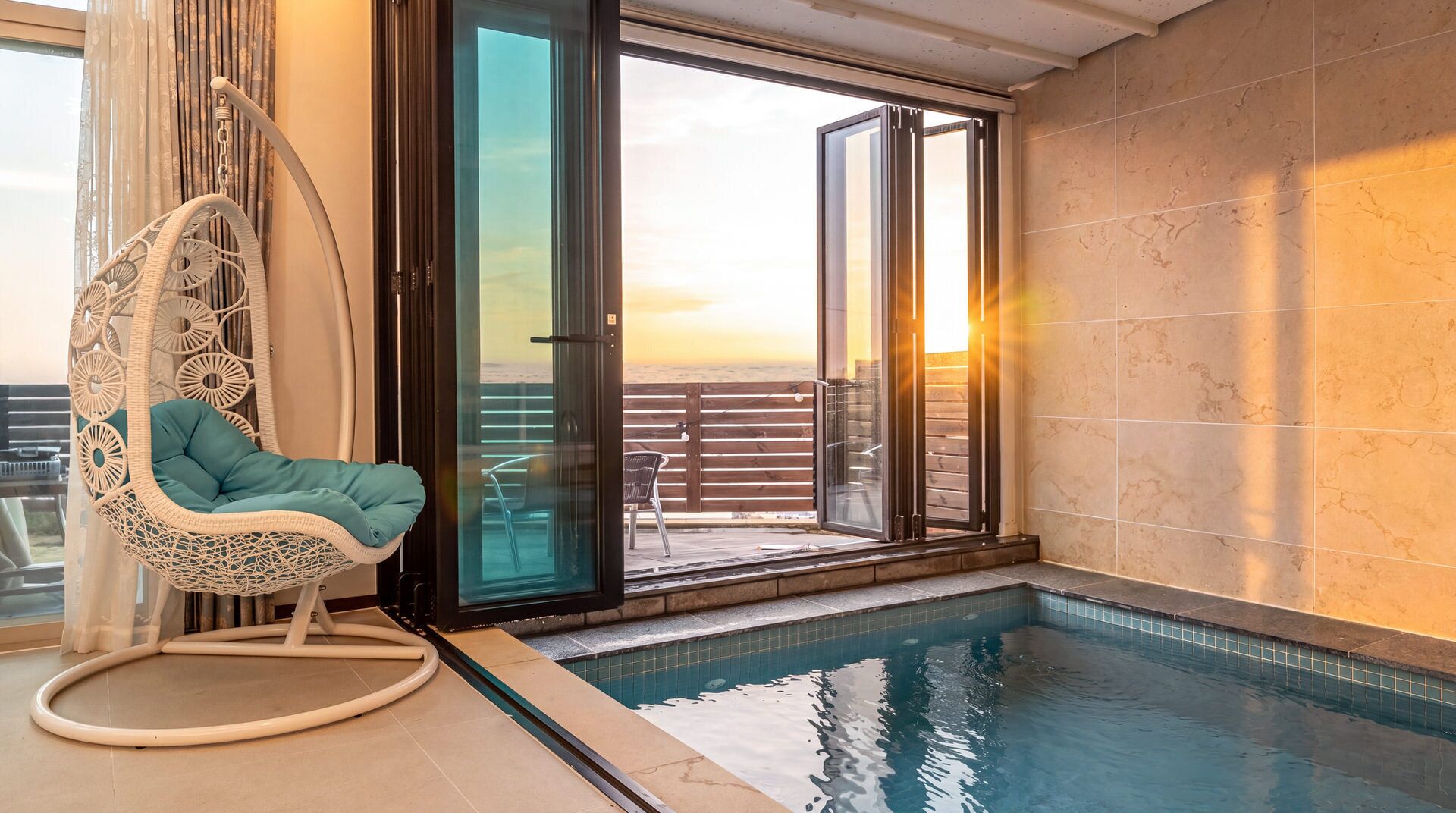 Zona de piscina con una silla colgante, una puerta de cristal que da a una terraza y una pared de azulejos.