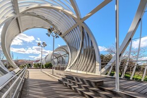 A modern architectural bridge with a wooden walkway and metal railings.