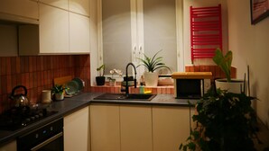 Een moderne keuken met een centraal eiland, een magnetron en verschillende planten.
