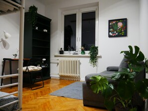 A room with a bunk bed, a radiator, a grey sofa, and a window with a view. - Spacious, designer 3-room apartment in  center of warsaw (Warszawa)