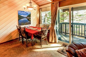A dining area with a table, chairs, and a view of a lake through a glass door. - Peaceful 1 bedroom + Loft condo in Mammoth Lakes perfect for your getaway (Mammoth Lakes)