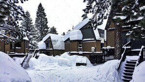 A snow-covered outdoor area with a staircase leading to a building, surrounded by snow-laden trees. - Peaceful 1 bedroom + Loft condo in Mammoth Lakes perfect for your getaway (Mammoth Lakes)