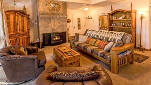 A cozy living room with a fireplace, leather furniture, and a bookshelf. - Peaceful 1 bedroom + Loft condo in Mammoth Lakes perfect for your getaway (Mammoth Lakes)