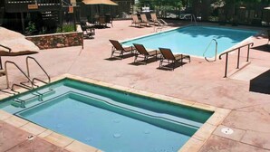 A swimming pool with lounge chairs and a separate hot tub area. - Peaceful 1 bedroom + Loft condo in Mammoth Lakes perfect for your getaway (Mammoth Lakes)