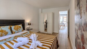 Une chambre d’hôtel avec un lit, une armoire, un bureau et une vue sur l’extérieur.