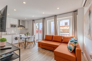 Een modern appartement met keuken, eethoek en woonkamer.