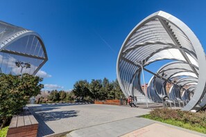 Een modern architectonisch gebouw met een rond ontwerp, een verhard pad en begroening.