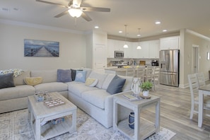 A modern living room with a sectional sofa, a coffee table, and a dining area with chairs. - Stunning and Gorgeous with Comm Pool, Tennis, Pickleball, Bikes, Free Activities Inc Golf @ Bear Tra (Rehoboth Beach)
