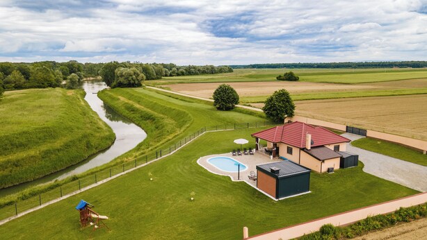 A house with a swimming pool, a tennis court, and a large lawn. - Riverside retreat with pool, summer kitchen, playground, and peaceful Drava views. (Pitomača)