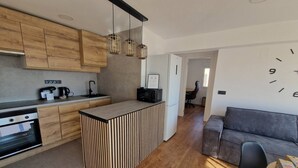 A modern kitchen with wooden cabinets, a central island, and pendant lighting. - Spacious 3 Bedroom Apartment With Balcony and AC in Castellón (Castelló de la Plana)