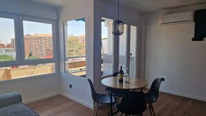 A modern dining area with a round table, four chairs, and a hanging light fixture. - Spacious 3 Bedroom Apartment With Balcony and AC in Castellón (Castelló de la Plana)