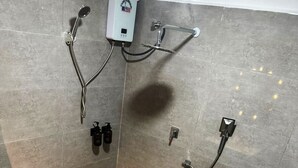 Ein Duschbereich mit Handbrause, Kopfbrause und einer zusätzlichen Handbrause.
