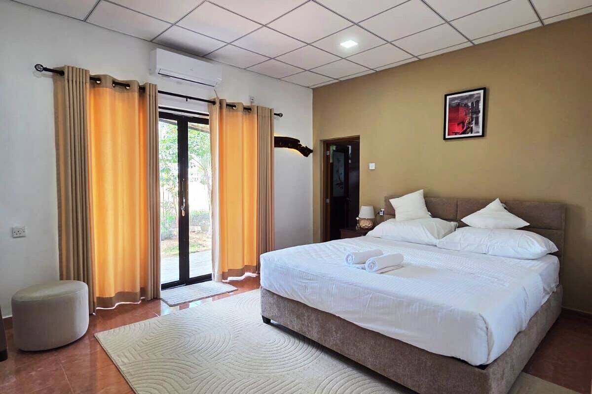 Een hotelkamer met een groot bed, een flatscreen televisie, een bank en een eettafel.