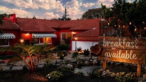 Un bâtiment rouge avec une enseigne indiquant qu’il est possible de prendre le petit-déjeuner sur place.