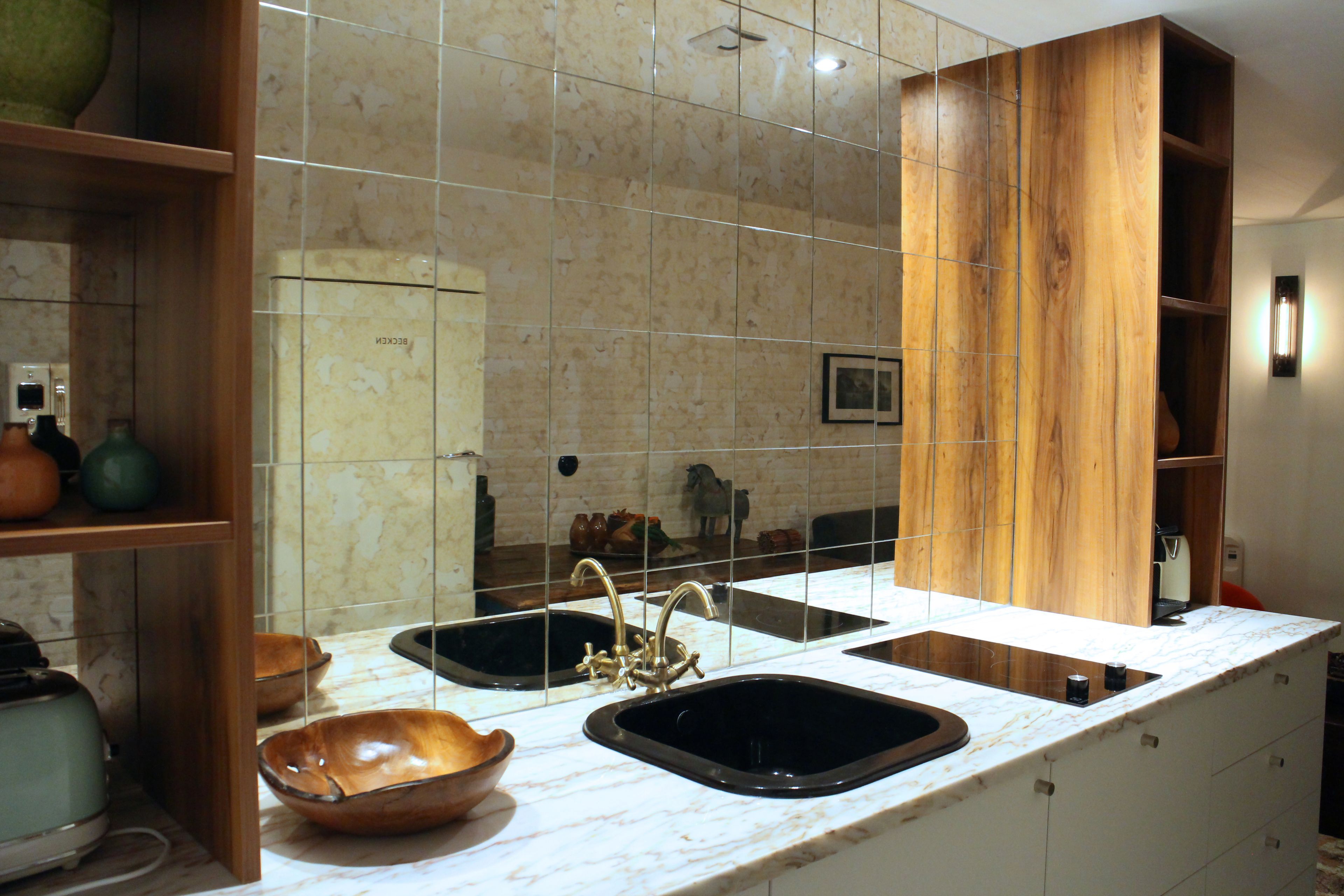 A kitchen with two sinks, wooden cabinets, and a marble countertop.