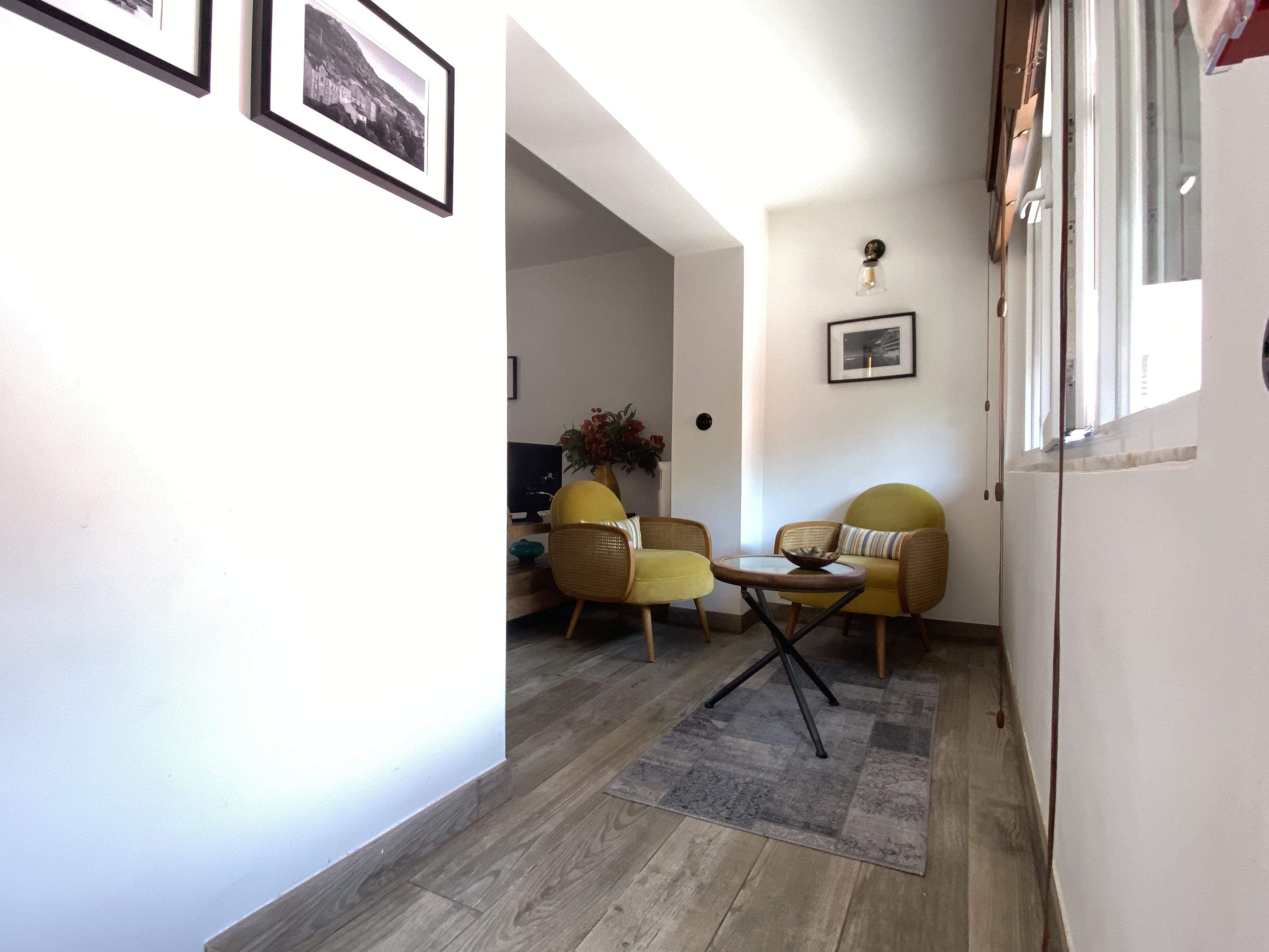 A living area with a sofa, chairs, a coffee table, and a TV.