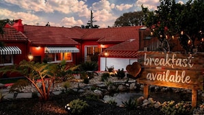 A red building with a sign indicating breakfast is available. - Storytellers - Checkinhome- T1 (São Pedro)