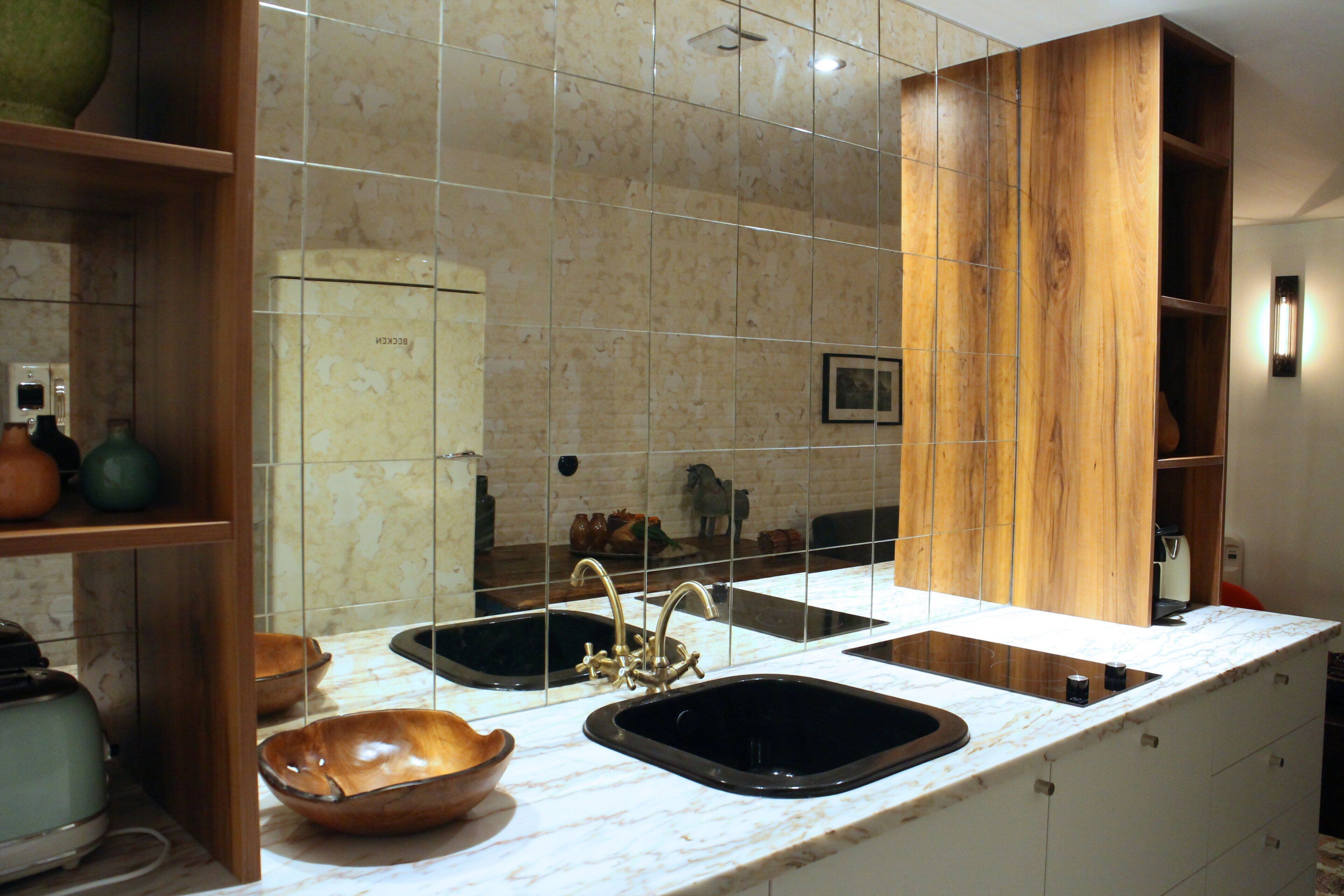 A kitchen with two sinks, a wooden cabinet, and a marble countertop.