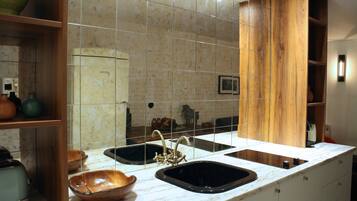 A kitchen with two sinks, a wooden cabinet, and a marble countertop.