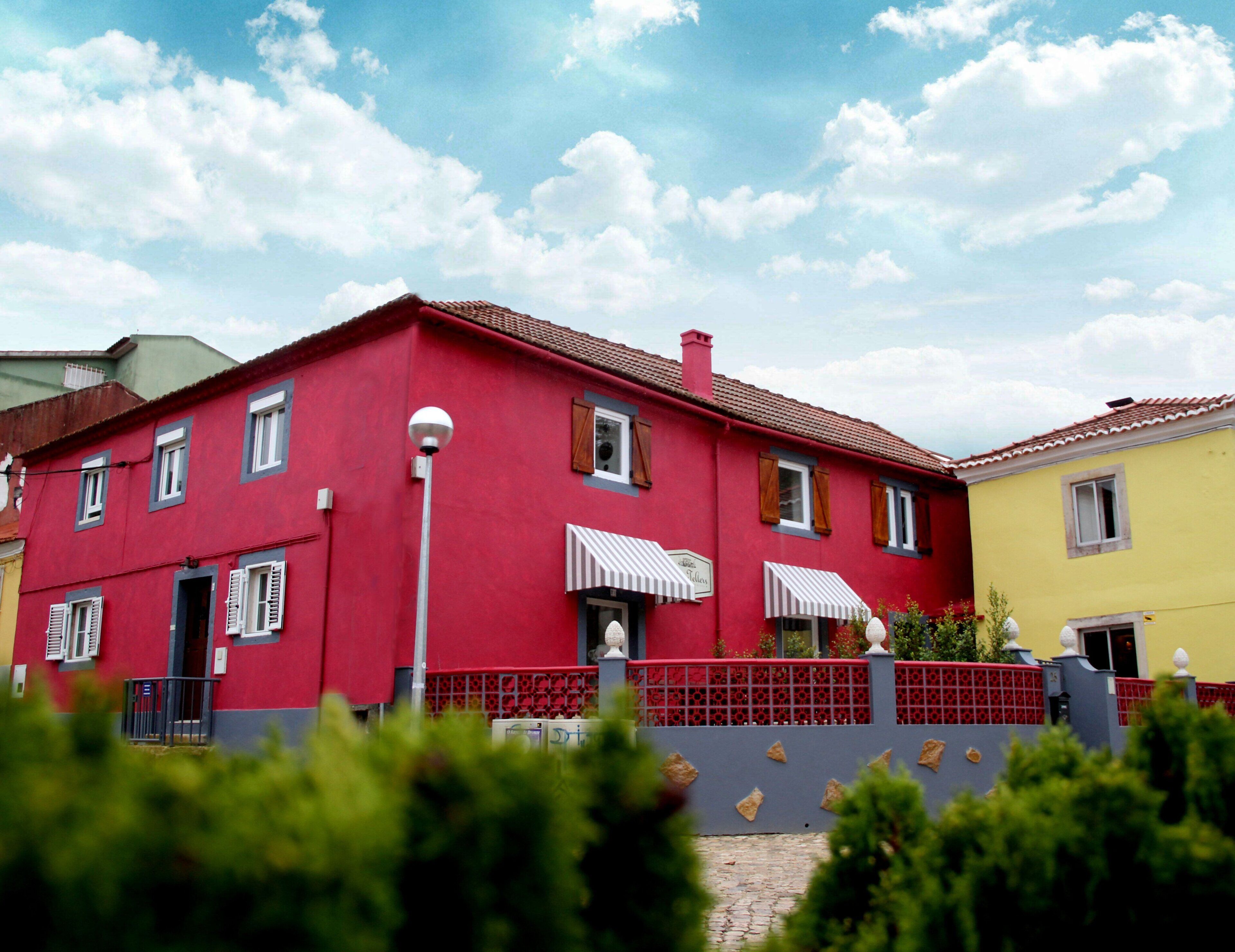 A red building with multiple windows and a red fence.