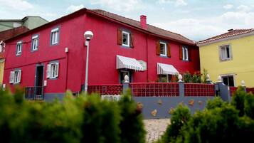 A red building with multiple windows and a red fence.