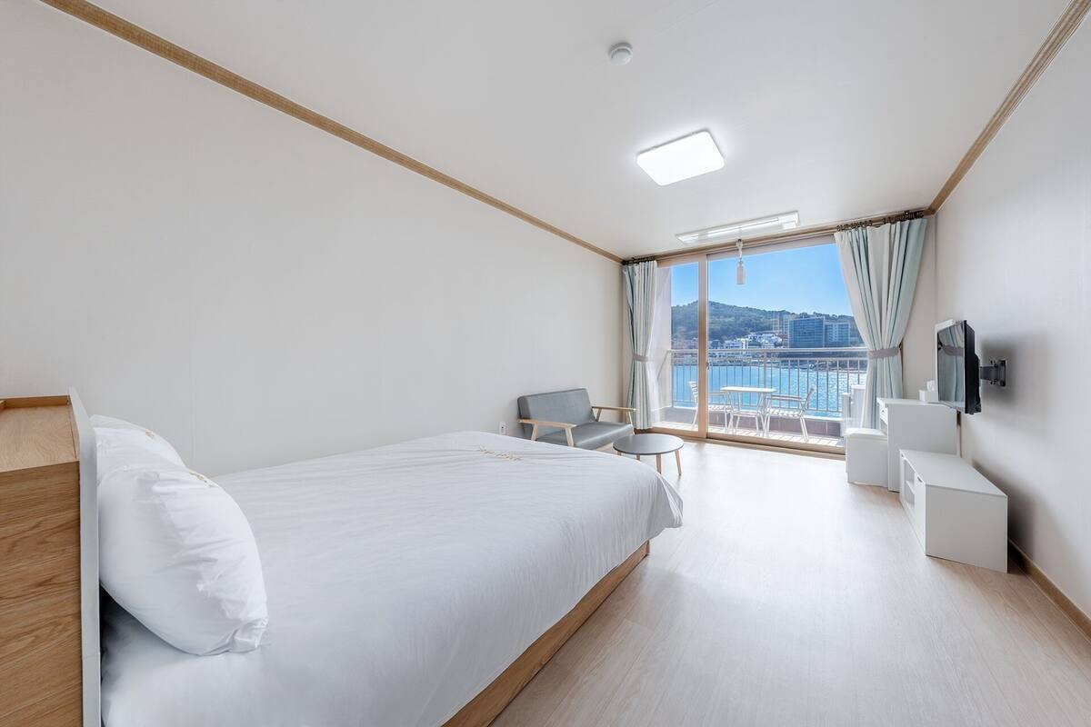 Ein Hotelzimmer mit Bett, Schreibtisch, Stuhl und Fernseher.